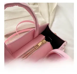 Close-up of smooth golden metal zipper and black lining on pink denim quilted bag