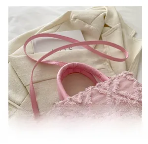 Pink quilted denim bag detail featuring fringe texture and adjustable shoulder strap