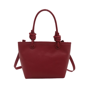 Elegant red litchi grain leather bucket bag with knotted handles and crossbody strap