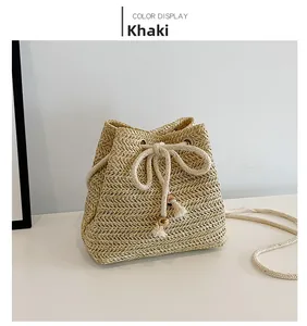 Detail of khaki straw bucket bag with drawstring closure and wooden bead accents