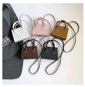 Flat lay of mini crossbody bags in five colors with M-letter monogram pattern