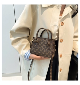 Detail of a mini crossbody bag with vintage M-monogram pattern and textured leather finish