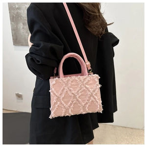 Pink quilted canvas handbag with fringe texture shown from a side-view on a model