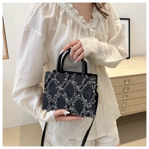 Quilted denim shoulder bag with white fringe details and retro top handle design