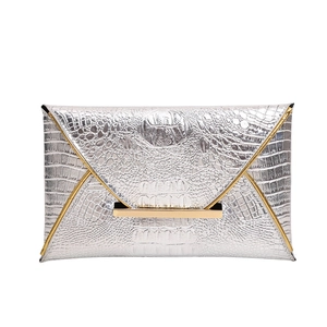 Silver envelope clutch bag with crocodile texture and gold metallic trim on white background