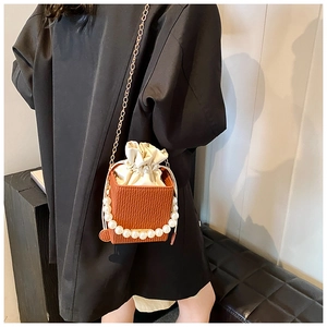 Close-up of orange textured mini square bag with large faux pearl handle and metal chain
