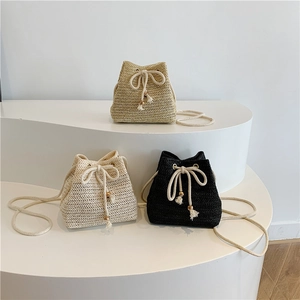 Straw woven drawstring bucket bags in beige and black with elegant rope chain straps