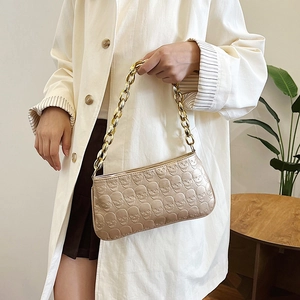 Vintage champagne gold shoulder bag with embossed skull patterns and thick chain strap