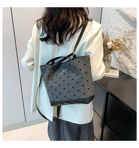 Detail of gray canvas tote with black polka dots and silver bow metal buckle accent