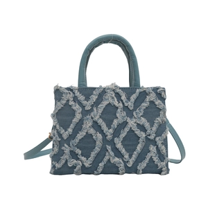 Quilted denim shoulder bag with fringe trim and top handle in vintage blue finish
