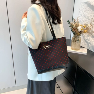 Classic black tote bag with red heart pattern and silver bow decoration for daily commute