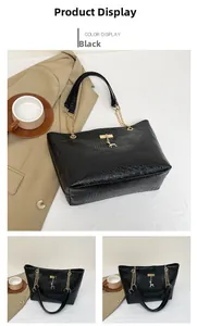 Close-up of black crocodile pattern tote bag with gold chain and deer charm detail