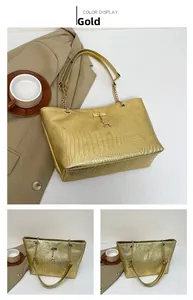 Detailed view of golden tote bag featuring crocodile pattern and metallic deer pendant charm