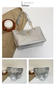 Detail of silver crocodile pattern tote bag with gold chain and deer pendant