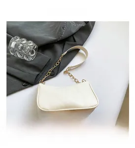 Detailed view of the creamy white baguette bag with elegant golden chain strap