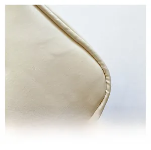 Close-up of beige litchi grain PU leather showing detailed stitching on the small square bag