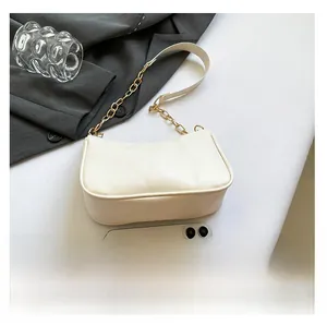 Close-up of off-white PU leather baguette bag with gold chain and smartphone for size scale