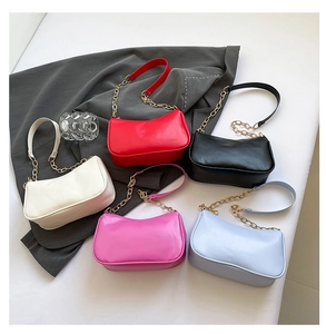 Detail of minimalist crescent shoulder bags in five vibrant colors with gold chain straps