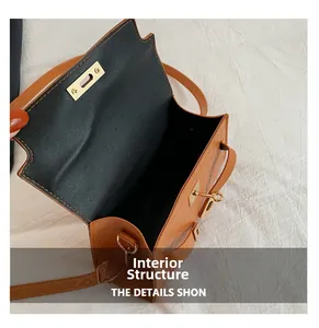 Detail view of the brown leather bag interior with golden twist lock and black lining