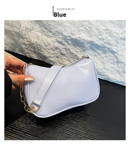 Detail of light blue crossbody bag featuring a thick metal chain and smooth leather strap