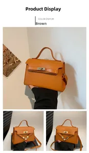 Detail view of a brown crocodile pattern crossbody bag with gold-tone twist lock and strap