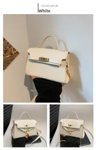 Detail of white crocodile pattern small square bag with golden turn-lock and handle