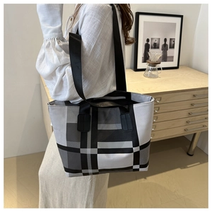 Detail of checkered patchwork tote bag showing large capacity and black fabric strap