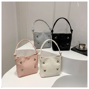Vue détaillée de sacs seaux avec papillons en métal et poignées nouées en quatre couleurs