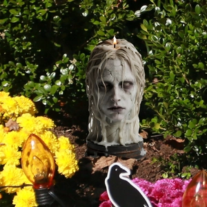 Creepy cracked face candle decoration with melting wax for Halloween garden decor