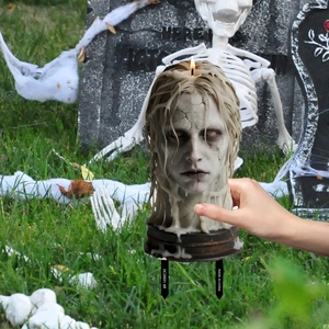 Spooky candle with cracked face detail on a metal stake for Halloween garden decor