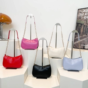 Collection of chic faux leather baguette shoulder bags in five vibrant colors on a podium