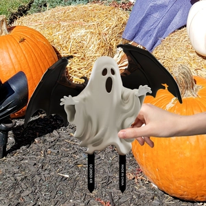 Close-up of white ghost yard stake with black wings for Halloween garden decoration