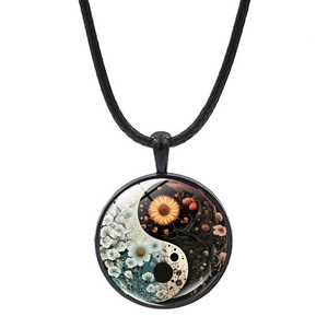 Detailed close-up of a Yin Yang glass pendant featuring floral patterns and black cord