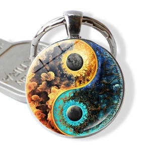 Macro shot of Yin Yang glass cabochon keychain with celestial nebula and star patterns