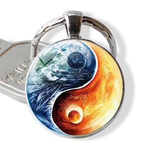 Detail view of round tai chi keychain featuring blue earth and sun yin yang patterns