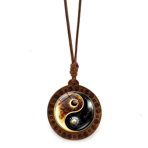 Detailed view of Yin Yang wooden pendant with carved cloud patterns on dark wood frame