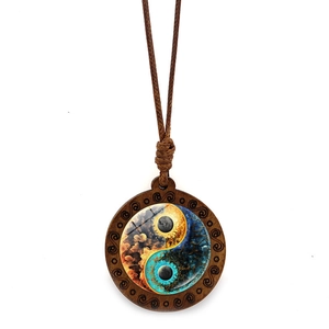 Detailed close-up of Yin Yang wooden pendant with orange cloud and blue tree textures