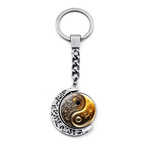 Close-up of rotatable Yin Yang pendant with vintage crescent moon and silver key ring