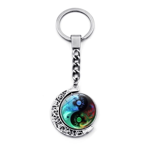 Detail of creative crescent moon keychain featuring a colorful yin yang tai chi glass pendant