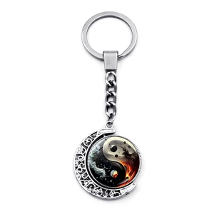 Detail of silver moon keychain with rotating yin yang pendant and hollow patterns