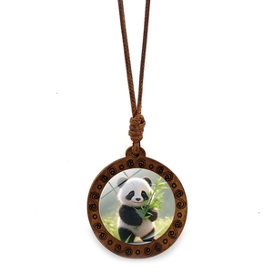 Detail of wooden panda pendant with hand-carved edges and colorful bamboo illustration