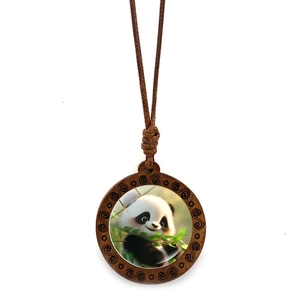 Detail of round wooden panda pendant with vintage spiral texture on brown braided rope
