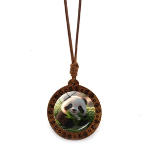 Macro detail of round wooden panda pendant with glass insert and spiral carved frame