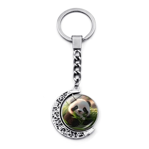 Detailed view of silver crescent moon keychain with rotating panda glass gem pendant