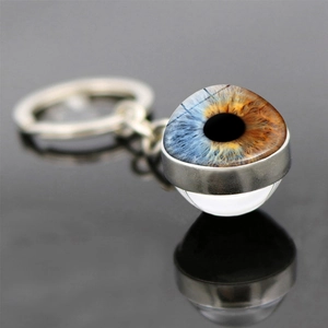 Macro shot of eye pupil keychain with double-sided crystal glass and metal base detail