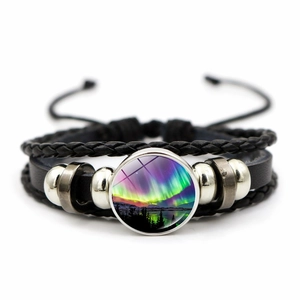 Detailopname van gevlochten leren armband met glazen cabochon van het Noorderlicht