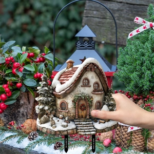Detailed view of a Christmas house garden stake with snowy miniature winter scene motifs