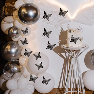 Detail van zwarte holle vlinderstickers op een witte taart en feestelijke decoraties