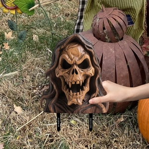 Close-up of hooded skull garden stake with fangs and vintage wood texture finish