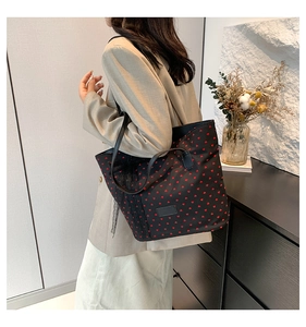 Détail du sac cabas noir avec motifs cœurs rouges et finitions en dentelle fine